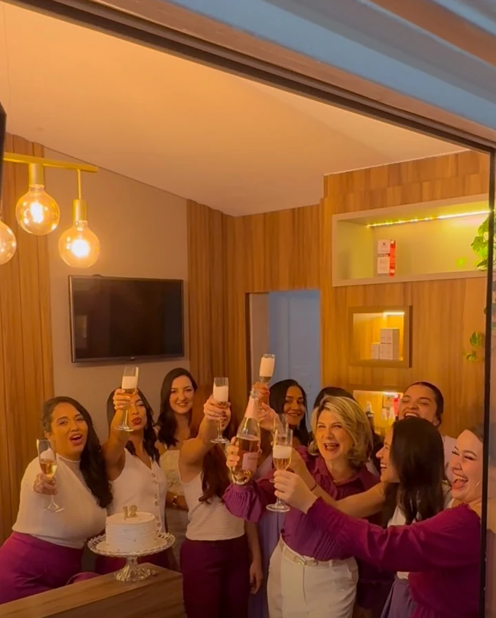Equipe brindando no espaço de madeira da clínica